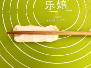 16、自制健康油条,用筷子在面皮中间压一下,油条生坯就做好了