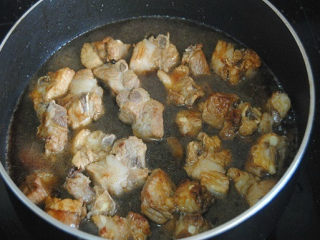 5、土豆烧肉,倒入没过排骨一半的清水，盖上锅盖焖煮10分钟；