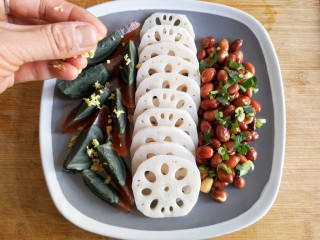 13、老醋三宝#吃出好身材#,把切好的皮蛋，焯好的藕片，炒好的花生米摆入盘中。在花生米上撒上香菜末，把姜末撒在皮蛋上。