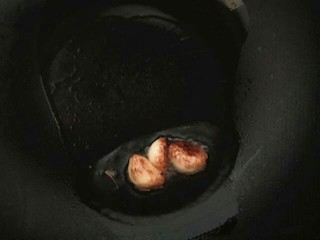 8、经典红烧肉,另起炒锅,放入少许植物油,放入大蒜,开小火,把大蒜煎黄关火备用。