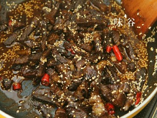 11、麻辣牛肉条,倒入牛肉翻炒,使牛肉均匀的粘上芝麻和辣椒油,放入适量的糖,盐和酱油,可以试一下味道。