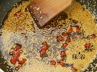 10、麻辣牛肉条,多余的油倒出,锅内留多点油,油热后倒入芝麻,辣椒粉花椒粉和辣椒进行翻炒,炒到香味溢出。