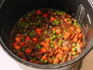 4、鲮鱼焖饭,把所有的料加到电饭锅里。我加的大米是两个人的份.加入胡萝卜、豌豆、酱油、生抽、糖和白胡椒粉。混合一下。加水，选煮饭。