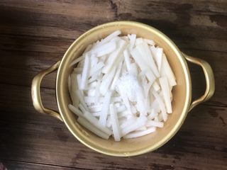 2、爽口腌萝卜,将切好的萝卜条装进容器放入食盐