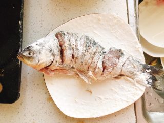 7、油炸糖醋版孔雀开屏鱼-年夜饭、宴请菜类,把腌好的鱼稍微沥下放到油炸粉里，使鱼裹满油炸粉，从内到外，全身裹满。