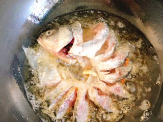 10、油炸糖醋版孔雀开屏鱼-年夜饭、宴请菜类,将漏勺一起放到锅中炸一会稍定型后，轻轻将漏勺抽出。