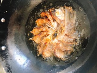 11、油炸糖醋版孔雀开屏鱼-年夜饭、宴请菜类,炸至一面金黄后翻面，借助漏勺和一双筷子可轻松翻面。