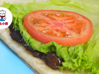 3、自制KFC嫩牛五方,将五边形纸片放置在案板上，铺上墨西哥饼皮1张，将面饼顶部沿纸片边缘翻折，依次铺入牛肉条，再放上玉米片、生菜叶2片、番茄片1片，挤上沙拉酱