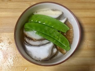 7、煎鳕鱼果蔬汇,取碗加开水，放入香菇片和荷兰豆，放入微波炉加热一分钟
