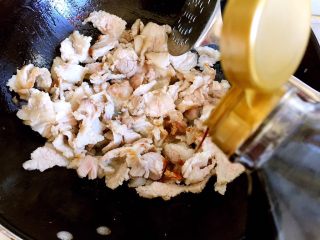 6、炒五花肉,倒入酱油。