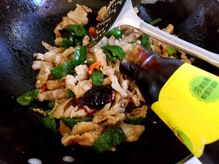 8、炒五花肉,翻炒片刻后倒入蚝油。