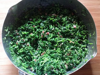 10、苜蓿香肠百叶卷,倒入苜蓿草锅中、然后用筷子快速将其搅拌均匀备用