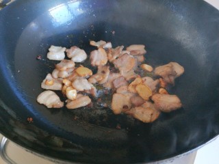 4、新文美食  麻辣椒香爆炒西芹,锅中放入适量油烧热，放入五花肉炒出油，放入适量葱姜蒜炒香。