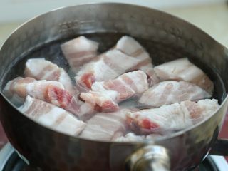 3、红烧肉炖萝卜,将五花肉冷水下锅，大火烧开后再煮两分钟，用勺子撇掉表面的浮沫