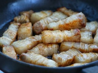 6、红烧肉炖萝卜,接着放入五花肉，翻炒至五花肉挂上糖色，肉的表面呈焦黄色