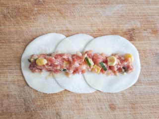 7、玫瑰花蒸饺,取三张饺子皮,把饺子皮搭边叠起,中间放上馅。