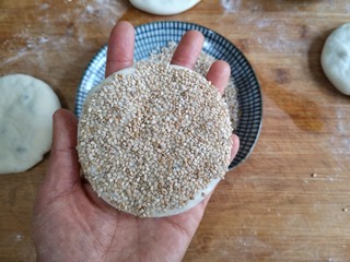 17、梅干菜肉烧饼,将刷水的一面按在芝麻盘中，沾一下。