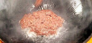 7、葱爆牛肉,把锅烧热，倒入适量的食用油，下牛肉片翻炒。