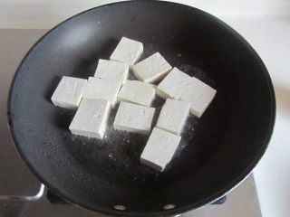 2、雪菜肉末烧豆腐,烧热锅，放少许油， 将切成小块的豆腐下去煎；