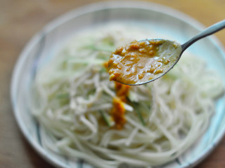 9、鸡丝酱拌面,接着捞出，摆入碗中，摆上鸡胸肉和黄瓜丝，最后淋上酱汁，拌匀即可