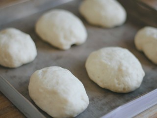 6、美式香肠热狗,将面团整形成椭圆形,放进烤盘,再一次放在温暖处发酵,差不多膨胀至两倍大就可以了。