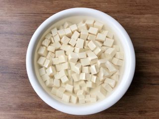 2、青菜豆腐汤,豆腐冲洗一下，切成小方块，放入碗里，加入一勺盐，适量清水浸泡半个小时，浸泡好冲洗干净，沥干水待用。