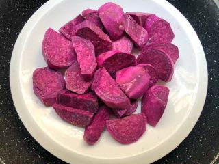 4、紫薯糯米丸子,把切好的紫薯放入盘里，蒸锅放入适量水烧开，放入蒸架，把紫薯放入蒸25分钟。