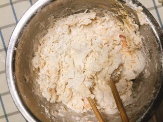 4、杂蔬沙拉面包,多次少量加入温水,搅拌成面块,搅拌后底部剩有少许面粉为宜。