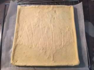 12、海苔肉松蛋糕卷,将烤盘放入170度预热好的烤箱中层，烘烤18分钟，直至蛋糕表面金黄即可，烘烤好的蛋糕卷放在烤网上，趁热撕掉烤纸，再放回原来的烤纸放凉