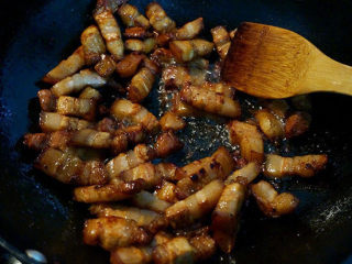 4、红烧肉炖鹌鹑蛋,将五花肉块倒入中小火翻炒，将肉块中的油脂煸出来直至再也不出油为主（煸出的油倒出炒别的菜用）；