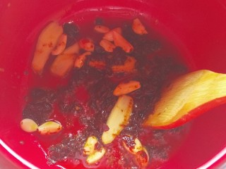 10、砂锅水煮肉片,待豆瓣酱炒出红油,加入姜片,蒜瓣炒香