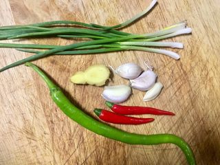 9、拌花心,猪心煮的时候，我们准备凉拌佐料，美人椒和红尖椒切细小节，香葱切葱花，大蒜老姜剁泥