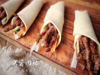 16、京酱肉丝,用焯好的豆腐皮卷起肉和菜。