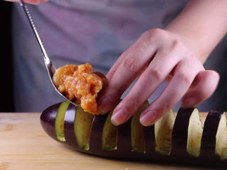 8、教你一个茄子的新吃法，又香又好吃一看就会,接着用勺子将之前腌制好的肉馅灌入茄条中。