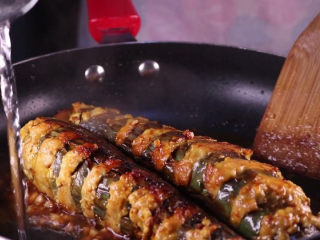 13、教你一个茄子的新吃法，又香又好吃一看就会,锅中留有少许的油，将蒜末下锅炒香，加入一勺的黄豆酱一同下锅翻炒，炒香后将茄条下锅，倒入两大勺的生抽、半杯清水。盖上盖子，中火焖上8分钟左右。