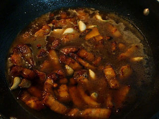 6、红烧肉炖鹌鹑蛋,沿着锅边倒入与肉持平的热水（不要倒在肉块上，这样焦糖色就能很好地保留在肉块表面了），也不要翻动肉块，盖上盖子，小火焖烧20分钟；