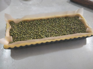 25、酸奶南瓜派,铺上油布，放上重物。我放的是绿豆，为的还是防止派皮鼓起。