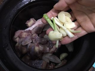 2、土豆焖鸡,鸡块清洗干净放入砂锅，放入蒜和葱白。