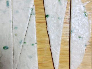 2、葱油飞饼香肠卷,将葱油味飞饼从冰箱拿出回温，切成等腰三角形。（宽度刚好能放下一根香肠）