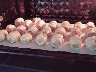 6、葱油飞饼香肠卷,烤箱200度烤20分钟左右。烤制过程中可以看到烤肠焦灼滋滋冒油的景象。