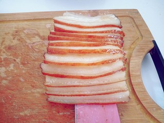 5、雪菜扣肉,切好的肉片用刀拖起。