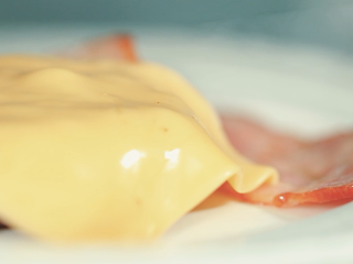 9、牛肉汉堡,放一片芝士在肉饼和培根上面。