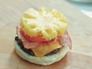 15、牛肉汉堡,最后放上一块切好的菠萝。在盖上另外一块汉堡胚。