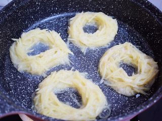 10、鸟巢土豆,平底锅中倒入适量的食用油烧热。把土豆丝放入平底锅中，把土豆丝整成圆形，中间留出一个洞