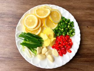 2、酸辣泡爪,柠檬洗净切片去籽，小米辣和青辣椒洗净切圈圈，生姜去皮洗净切片，蒜头去皮洗净，葱洗净切长段待用。