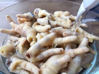 6、酸辣泡爪,鸡爪煮好，用漏勺捞到大碗里，加入纯净水，搅拌一下把水倒掉，再重新倒入纯净水，把鸡爪泡至完全凉透。