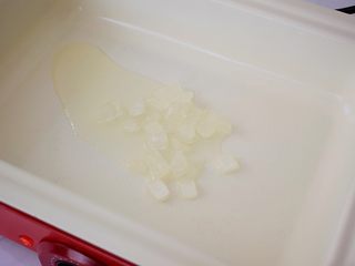 3、红烧排骨,锅中倒入适量的食用油烧热，放入冰糖翻炒至融化变成焦黄色