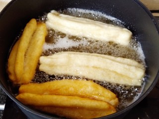 9、简单快手炸油条,先来炸大油条,把锅里油烧热,放入油条炸制,