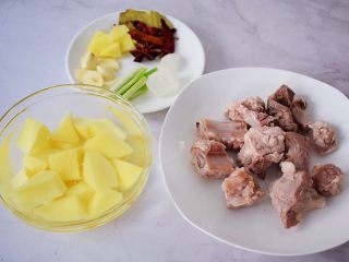 2、排骨炖土豆,排骨斩小块焯掉血水后冲洗干净备用，土豆去皮洗净切成小块放入清水中备用，姜切片，蒜切片，葱切葱花，备齐香料