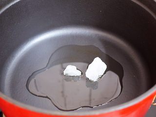 3、排骨炖土豆,锅中倒入适量的食用油烧热，放入冰糖翻炒至融化变成焦黄色